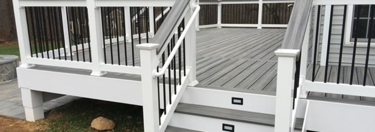 new deck with grey deck boards and black railings - Barefoot Construction Deck Construction, Basement Finishings and Home Additions