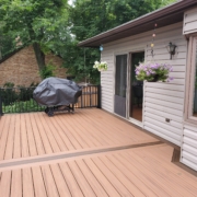 new deck with black railings and covered grill - Barefoot Construction Deck Construction, Basement Finishings and Home Additions