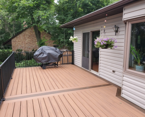 new deck with black railings and covered grill - Barefoot Construction Deck Construction, Basement Finishings and Home Additions