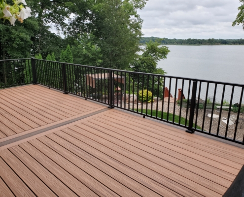 new deck with black railings and a lake view - Barefoot Construction Deck Construction, Basement Finishings and Home Additions