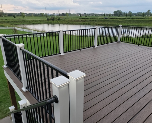 new deck with brown boards and black railings - Barefoot Construction Deck Construction, Basement Finishings and Home Additions