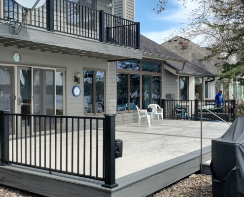new deck with light grey boards and black railings - Barefoot Construction Deck Construction, Basement Finishings and Home Additions