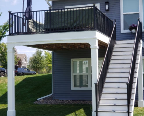 new second story deck with a blue patio umbrella - Barefoot Construction Deck Construction, Basement Finishings and Home Additions