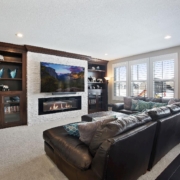 finished basement with stone fireplace dark wood cabinetry - Barefoot Construction Home Remodeling