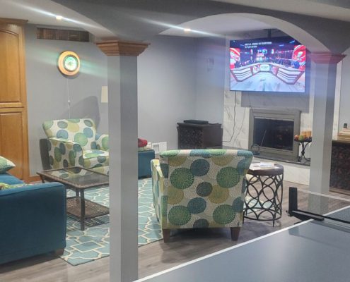 finished basement with stone fireplace and ping pong table - Barefoot Construction Deck Construction, Basement Finishings and Home Additions