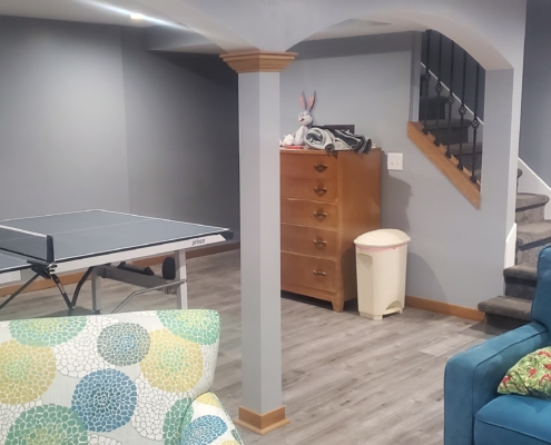 finished basement with stone fireplace and ping pong table - Barefoot Construction Deck Construction, Basement Finishings and Home Additions