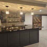 finished basement with bar and black stone countertop - Barefoot Construction Deck Construction, Basement Finishings and Home Additions
