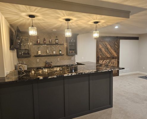 finished basement with bar and black stone countertop - Barefoot Construction Deck Construction, Basement Finishings and Home Additions