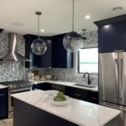 finished basement with a kitchenette with black cabinets and white countertops - Barefoot Construction Deck Construction, Basement Finishings and Home Additions