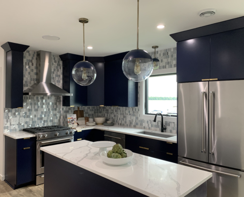 finished basement with a kitchenette with black cabinets and white countertops - Barefoot Construction Deck Construction, Basement Finishings and Home Additions