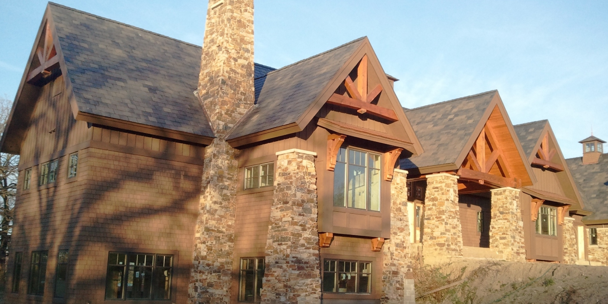 exterior of home with wood planks and stone - Barefoot Construction Deck Construction, Basement Finishings and Home Additions
