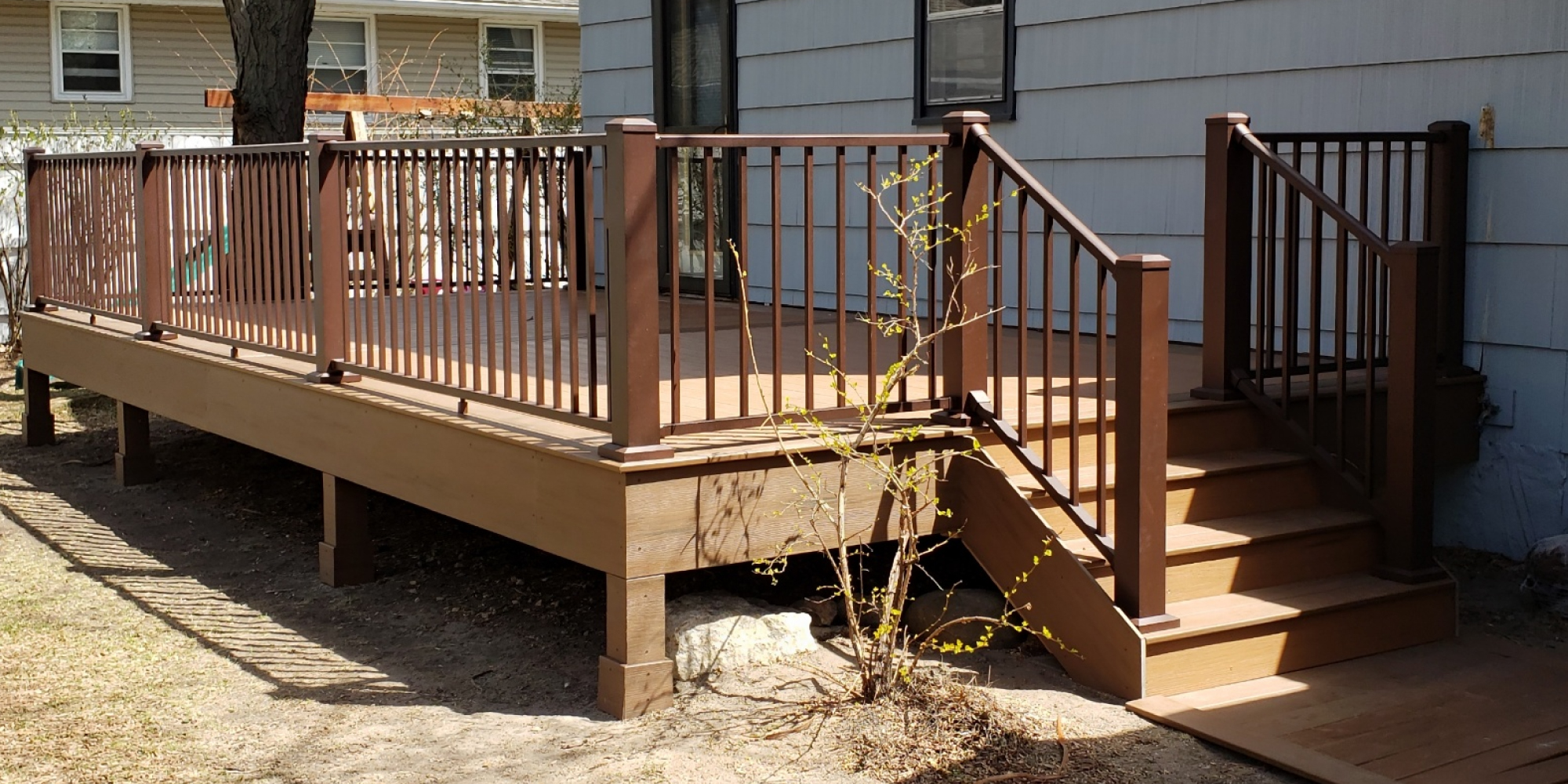 new wood deck with stairs and dark brown railings - Barefoot Construction Deck Construction, Basement Finishings and Home Additions