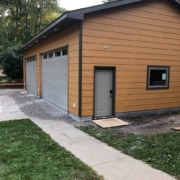 new wood siding and grey garage doors - Barefoot Construction Deck Construction, Basement Finishings and Home Additions