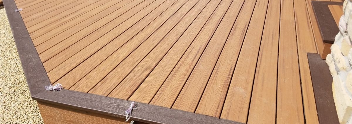 newly built composite deck with dark brown border - Barefoot Construction deck construction