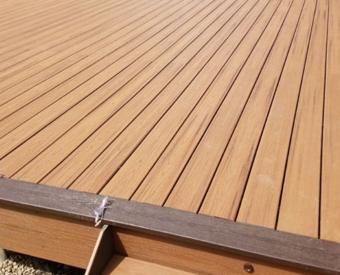 newly built composite deck with dark brown border - Barefoot Construction deck construction
