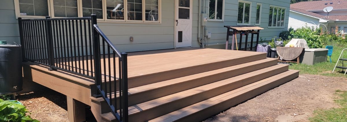 newly built deck with black railings and wood boards - Barefoot Construction deck builders near