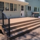 newly built deck with black railings and wood boards - Barefoot Construction deck builders near