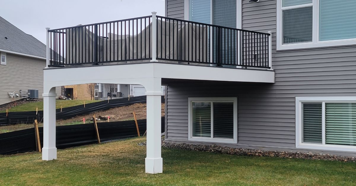 new white and black deck attached to grey house - Barefoot Construction composite deck