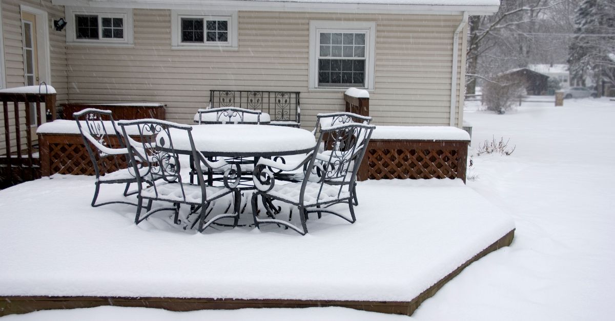 deck with a patio table covered in snow - Barefoot Construction deck construction