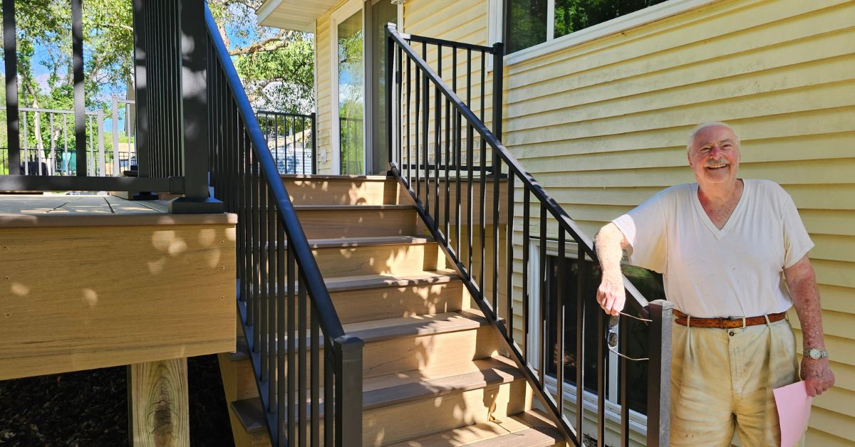 customer standing by newly constructed deck - Barefoot Construction deck construction