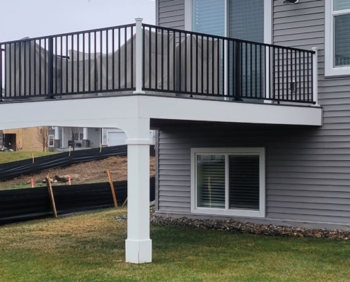 new deck with white columns and black railings - Barefoot Construction deck builders near