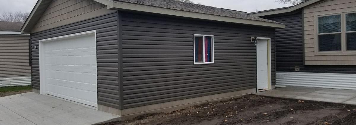 newly built home addition with a white door and dark grey siding - Barefoot Construction home addition