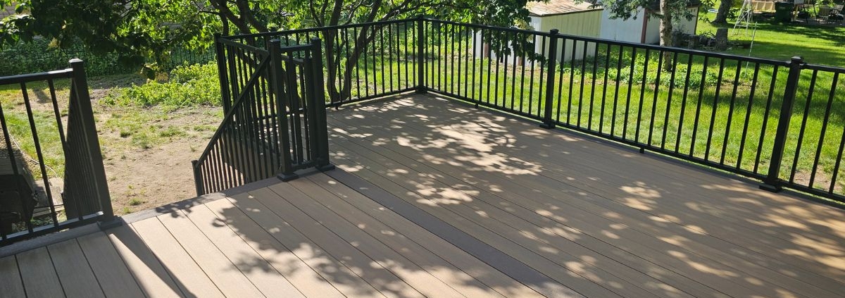 newly built deck with black railings - Barefoot Construction composite decking