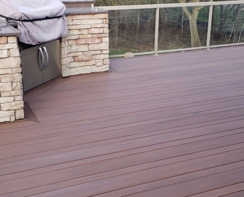 composite deck with a stone barbeque - Barefoot Construction composite decking