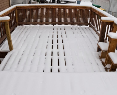 wood deck covered in snow - Barefoot Construction deck winterization