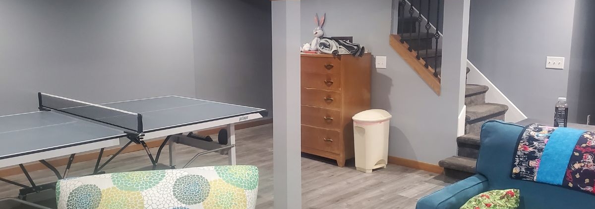 finished basement with grey walls and a ping pong table - Barefoot Construction basement finishing