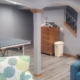 finished basement with grey walls and a ping pong table - Barefoot Construction basement finishing