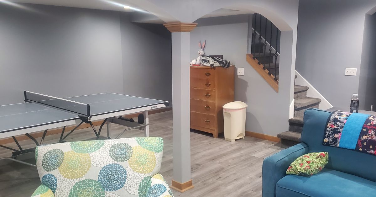 finished basement with grey walls and a ping pong table - Barefoot Construction basement finishing