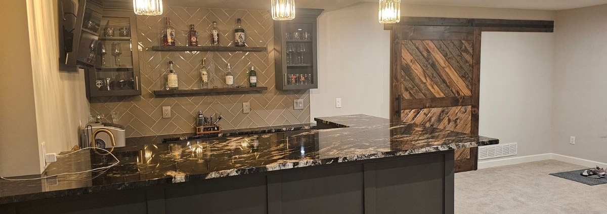 finished basement with a wet bar area - Barefoot Construction basement finishing