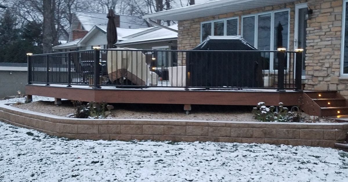 new deck with black railings during the winter - Barefoot Construction deck builders near