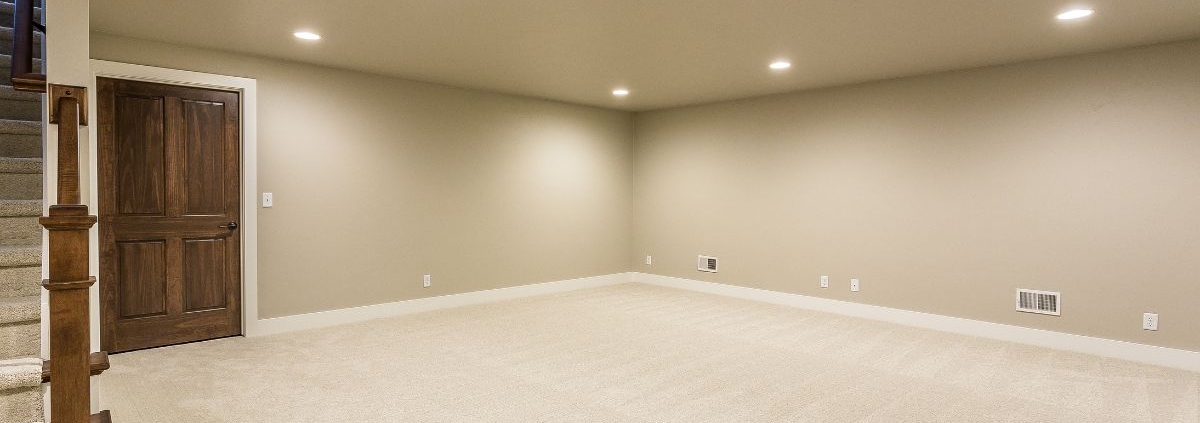 empty living space in a basement - Barefoot Construction basement finishing