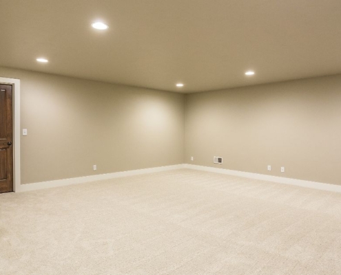 empty living space in a basement - Barefoot Construction basement finishing