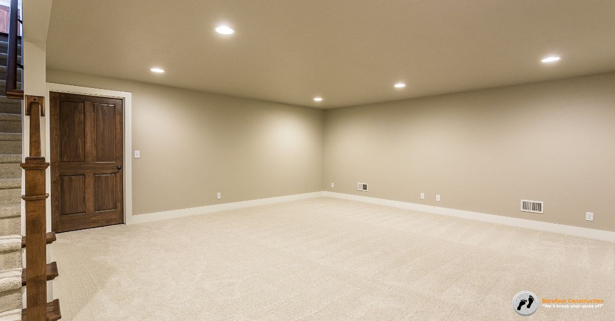 finished basement with white carpet and beige walls - Barefoot Construction basement finishing