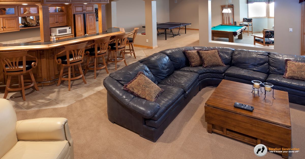 finished basement with a wet bar and leather couch - Barefoot Construction basement finishing