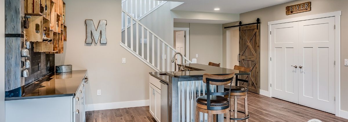 finished basement with a wet bar - Barefoot Construction basement remodel