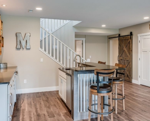 finished basement with a wet bar - Barefoot Construction basement remodel