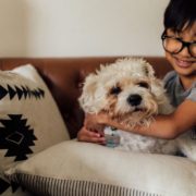 BarefootConstruction-basement-remodel-011020252 child wearing glasses hugging their white dog - Barefoot Construction Best Barefoot-Friendly Decking Materials for Kids and Pets