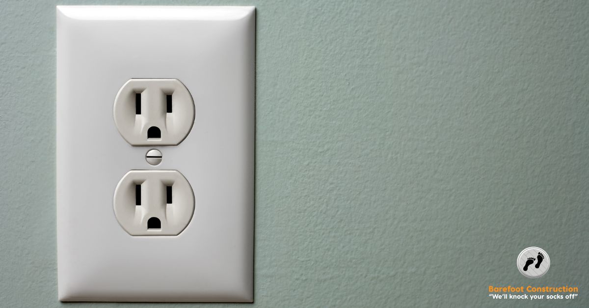 green blue wall with a white wall outlet with a white cover - Barefoot Construction basement finishing