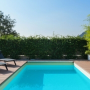 blue pool surrounded by deck boards and chairs - Barefoot Construction composite decking