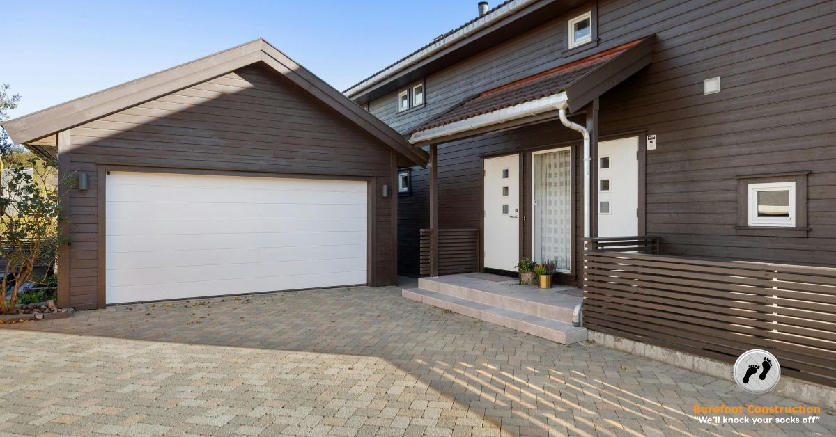 garage addition with dark grey vinyl siding and a white door - Barefoot Construction garage addition