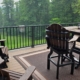 composite deck with patio furniture and a covered grill and a lake view - Barefoot Construction decking material cost comparison