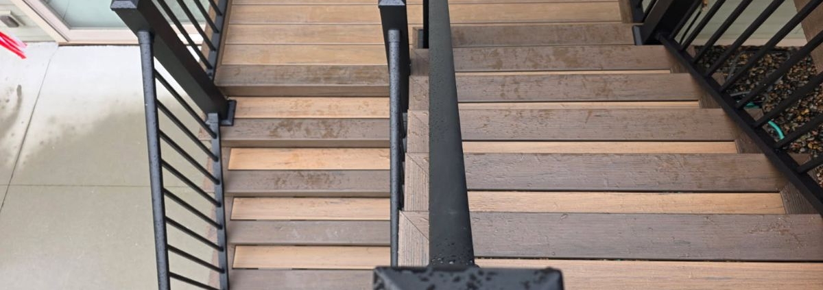 two tiered composite decking stairs with black rails - Barefoot Construction decking material cost comparison