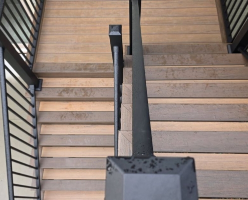 two tiered composite decking stairs with black rails - Barefoot Construction decking material cost comparison