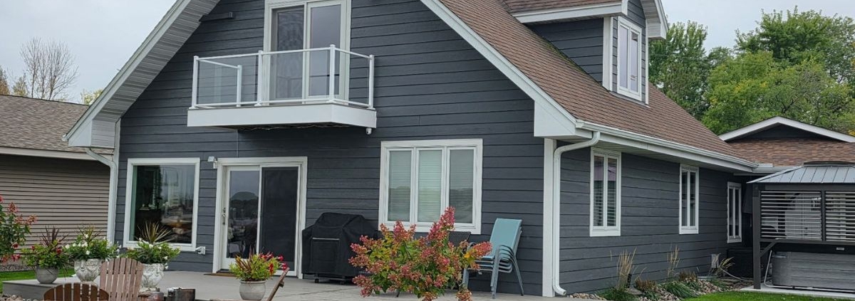 exterior of a home with grey siding and a composite deck - Barefoot Construction Basement Finishing ROI Maple Grove