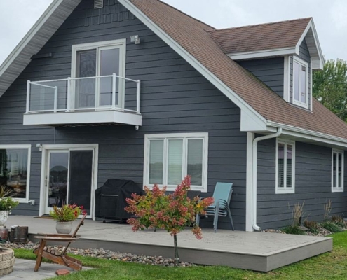exterior of a home with grey siding and a composite deck - Barefoot Construction Basement Finishing ROI Maple Grove