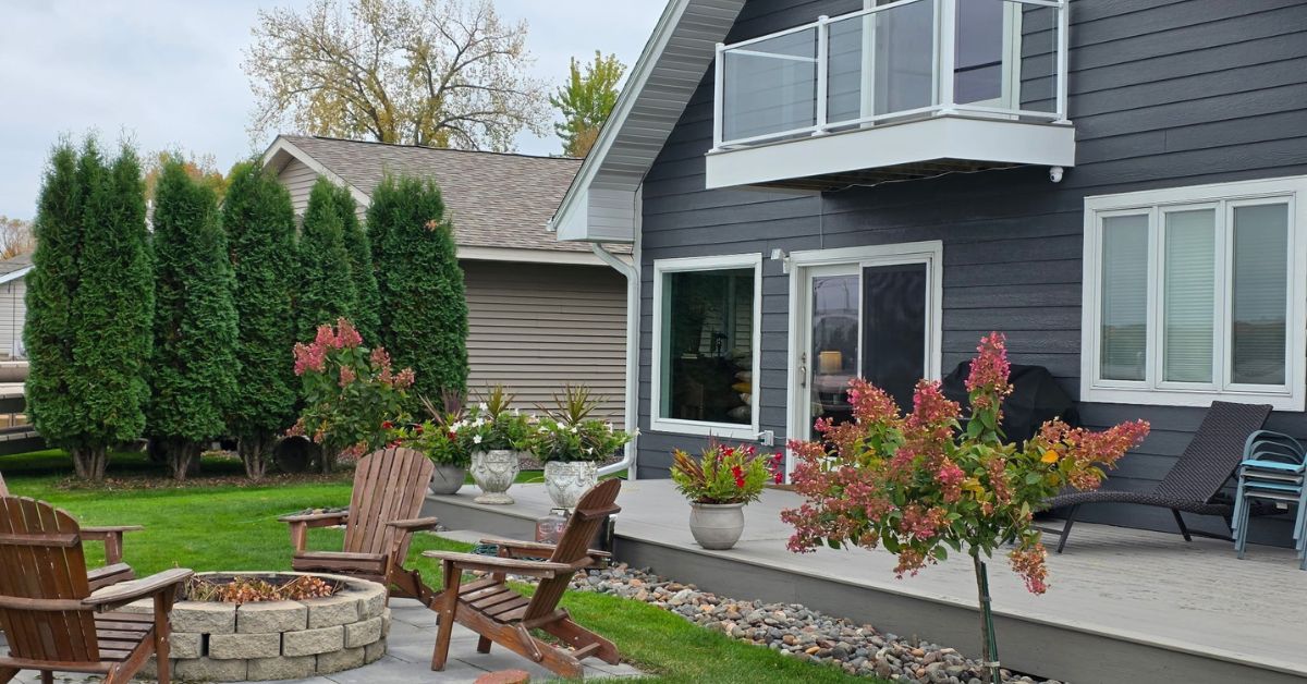 exterior of a home with grey siding and a composite deck - Barefoot Construction